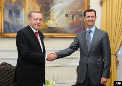 Bashar al-Assad shakes hands with Recep Tayyip Erdoğan